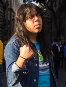 Joven con el puño levantado durante el atardecer en las calles del centro histórico de la Ciudad de México.
